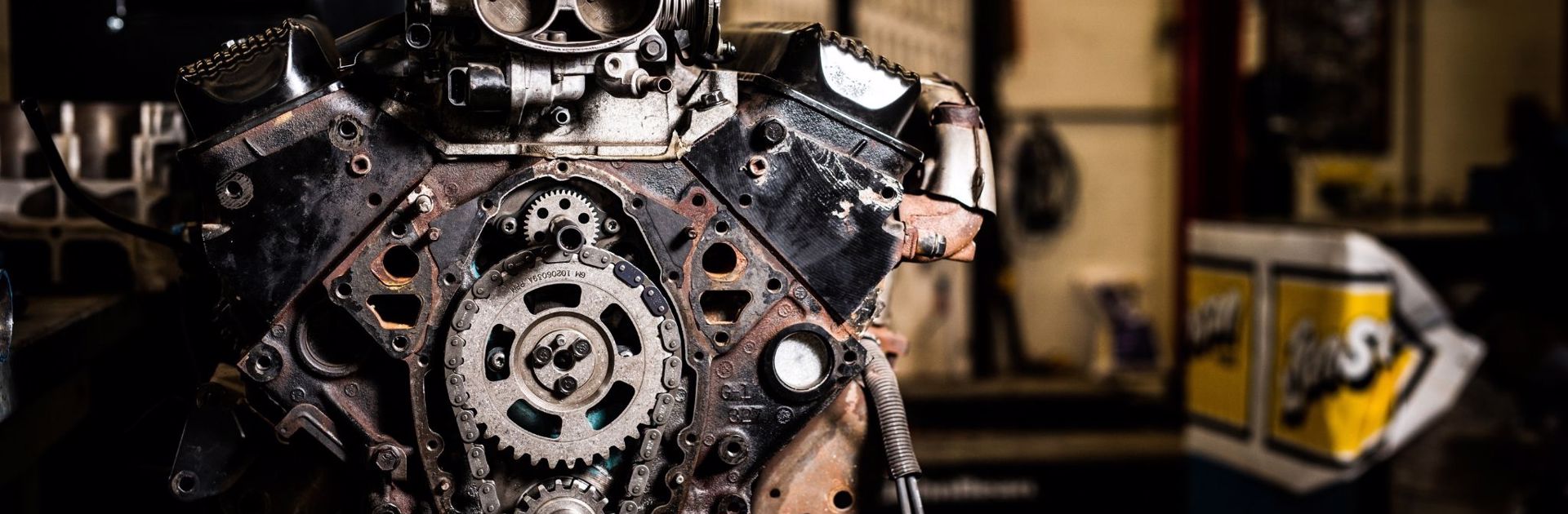 Close up shot of engine that has been worked on, held up on a stand inside of an autoshop